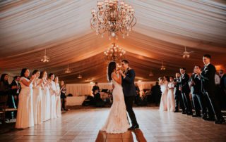 A couples first dance in the tented ballroom in the evening