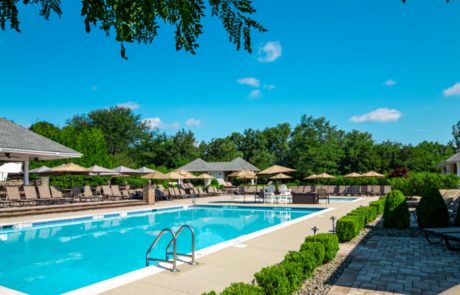 Vibrant blue swimming pool outside with cabanas