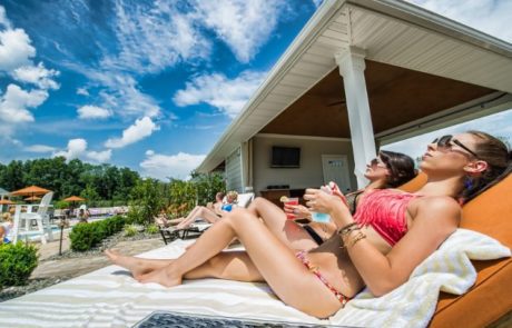 Two women lounging by the pool getting sun
