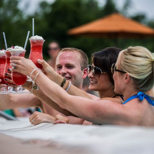pool-side-beverages Group of members toasting with drinks by the resort-style pool at West Hills Country Club, celebrating the exclusive Country Club Membership experience.
