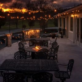 Outdoor balcony at night with string lights overlooking the golf course