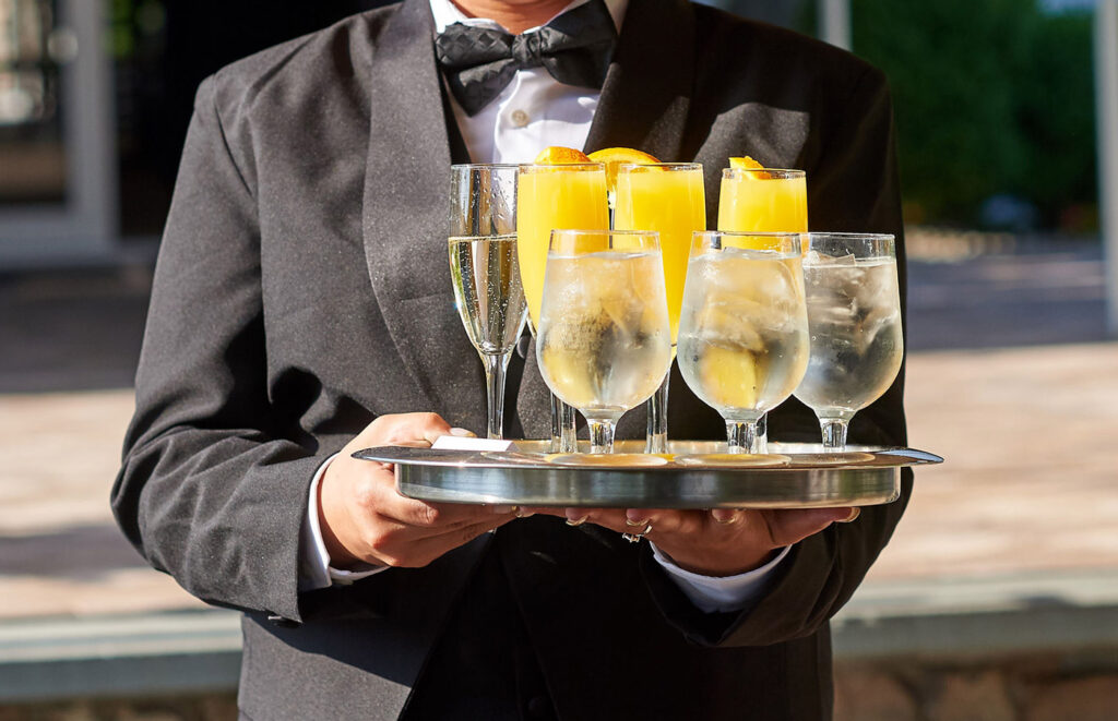 What is a Maître D'? Here is one bringing beverages to the wedding party