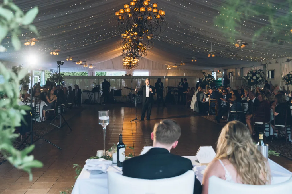 Couple sitting at their head table in our tented ballroom